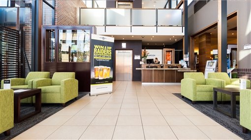 The foyer and lounge at The Mawson Club, with green armchairs and the reception desk